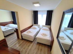凯尔采Hotel SiLL的小房间设有两张床和镜子