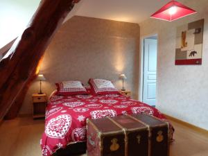 康庞La Boucle de l'Adour Chambres d'Hôtes & gîtes的一间卧室配有一张红色的床,上面有一条裤子