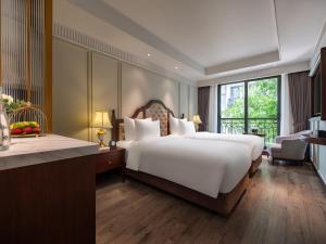 河内GRAND HOTEL du LAC Hanoi的一间卧室设有一张大床和一个大窗户