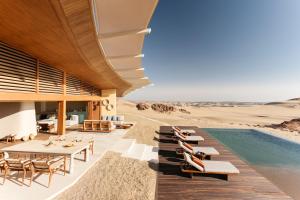 Six Senses Southern Dunes, The Red Sea的沙漠中的度假村,设有游泳池和桌椅
