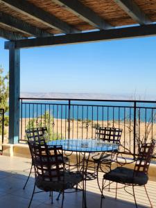 Chorazimמול הכנרת Over looking the Sea of Galilee的海滩景阳台配有桌椅