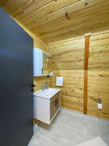 PazarGreen Luxury Bungalovs的一间带白色水槽和木墙的浴室
