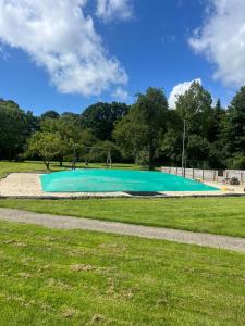布勒鲁普Assersbølgård的公园里的小型绿松石游泳池