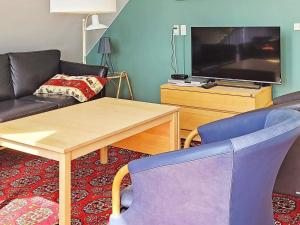 罗莫柯克比6 person holiday home in R m的带沙发、桌子和电视的客厅