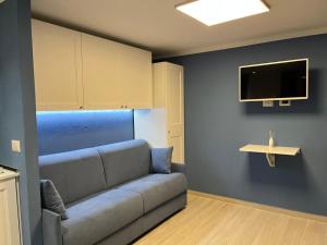 马里纳·迪·波迪斯科Blue Portisco的客厅配有沙发和墙上的电视