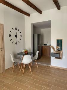 卡利斯托斯Giasemi apartments的一间带桌椅和时钟的用餐室