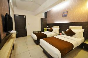 钦奈AN STAYS Chennai Airport的酒店客房设有两张床和一台平面电视。