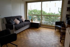 巴黎Entiry apartment, Private rooms in Paris的带沙发和大窗户的客厅