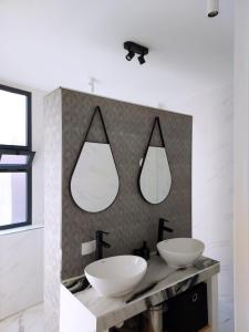 胡塞马Entire house with private rooftop的浴室设有两个水槽和两面墙上的镜子