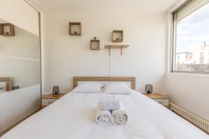 沙马列尔L'Echappée的卧室配有白色床和毛巾