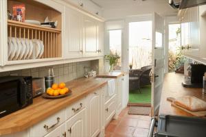 奇平诺顿Spring Cottage的柜台上放有橙子的厨房