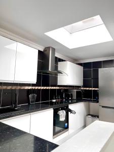AddingtonHomely Cozy 1 bedroom Apartment的厨房配有黑白橱柜和天花板