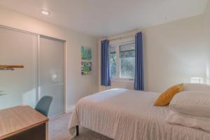费尔班克斯The Upper Fairbanks Street Retreat 1的一间卧室配有一张床、一张书桌和一个窗户。