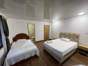 MonterreyCentro agroecoturistico las heliconias的酒店客房,配有两张带白色床单的床