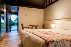 嘎林海斯港塞拉姆比度假酒店的一间卧室配有一张床和一张桌子及椅子