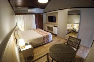 嘎林海斯港塞拉姆比度假酒店的酒店客房,配有床、桌子和椅子
