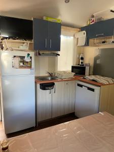 勒格罗-迪鲁瓦Mobil home 8 personnes camping l elysee的厨房配有白色冰箱和水槽