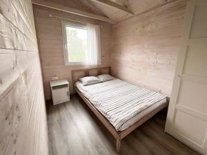 韦巴Domki Laba的木制客房的一张小床,设有窗户