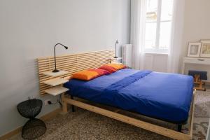 都灵Al n°35 - Una volta a Torino的一间卧室配有一张带蓝色床单和橙色枕头的床。