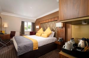 塞文欧克斯唐宁顿庄园酒店的酒店客房配有一张带黄色枕头的大床
