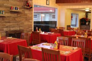 加纳诺克1000群岛帝国旅馆的餐厅设有红色的桌椅和砖墙