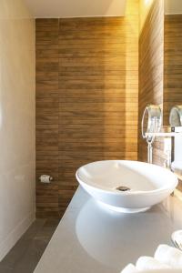 艾库玛尔Luxurious Apartments With BBQ Pool Garden Jungle View的浴室设有白色浴缸,拥有木墙