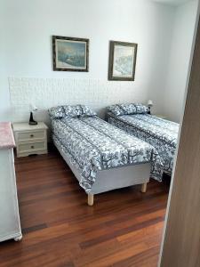 龙基德伊莱焦纳里Finestre Verdi appartamento con parcheggio的一间卧室设有两张床和床头柜