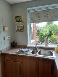 萨顿因阿什菲尔德Stunning Views Peaceful Split Level Bungalow的带水槽的厨房台面和窗户