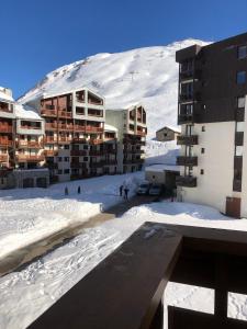 蒂涅Tignes : cocon luxueux au pied des pistes的一座雪地中的建筑,背景是一座山