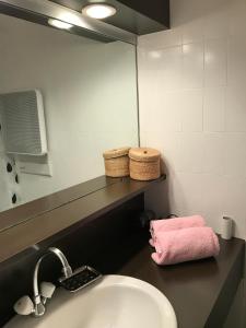蒂涅Tignes : cocon luxueux au pied des pistes的一间带水槽和粉红色毛巾的浴室