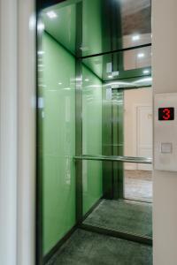 克卢日-纳波卡Ateneea Luxury Rooms的带有绿色墙壁和玻璃门的电梯