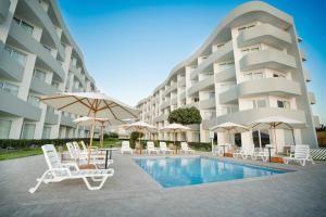 帕拉卡斯Casa Andina Select Paracas的游泳池旁的酒店拥有椅子和遮阳伞