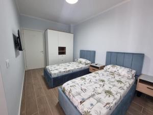 格勒姆H&E Sea view 2-Bedroom Apt Qerret的客房设有两张床和一张书桌