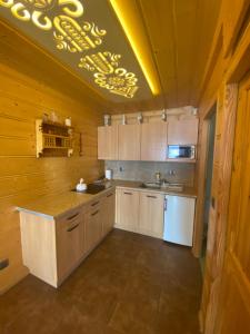 新塔尔格Domek w górach的厨房设有木墙和黄色灯天花板。