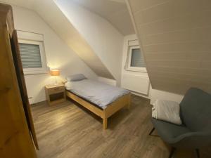 拜罗伊特Colmdorf Ferienhaus的一间小卧室,配有一张床和一把椅子