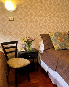 昆卡HOSTAL EL CAJAS的一间卧室配有一张床和一张花瓶桌子