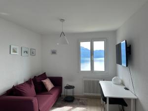 PuidouxRoom with 360° view overlooking Lake Geneva and Alps的客厅配有紫色沙发和窗户