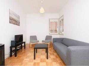 里斯本HOUZE_4 room apartment in Central Lisbon near Zoo的客厅配有沙发和两把椅子