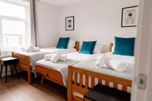 斯基普顿Sawley Cottage的一间蓝色枕头的房间里,有三张床