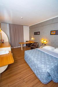 多拉杜斯H+ Hotel的配有一张床和一张书桌的酒店客房