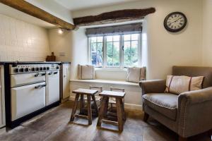 赛伦塞斯特Holly Cottage, Coln St Aldwyns, Cotswolds的厨房配有沙发、桌子和窗户。
