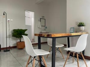 埃斯孔迪多港Casa Mura的一间带桌子和两把白色椅子的用餐室