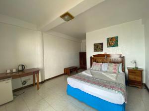 曼巴豪甘米金岛黄金日落海滩俱乐部度假村的卧室配有一张床