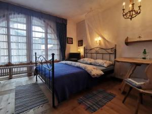圣玛利亚瓦尔姆斯塔尔Chasa de Capol - Historische Gaststätte & Weinkellerei的一间卧室设有一张床和一个大窗户