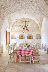 马丁纳弗兰卡Masseria Signora的一间用餐室,配有红色和白色的桌子和椅子