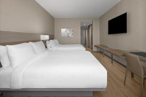 迈阿密AC Hotel by Marriott Miami Dadeland的卧室配有一张白色大床和一张书桌