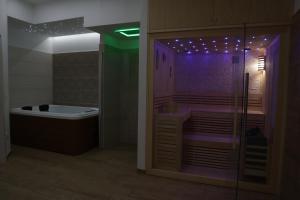 RicciaIl Riccio home & relax的浴室配有浴缸和紫色灯淋浴