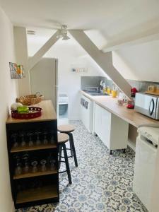 法莱斯L idylle de Guillaume的厨房配有白色橱柜和桌椅