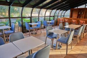 南雅茅斯All Seasons Resort, Trademark Collection by Wyndham的餐厅设有桌椅和窗户。