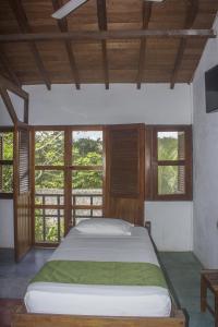 Puerto NariñoWaira Selva Hotel的一间卧室设有一张大床,窗户装在卧室内
